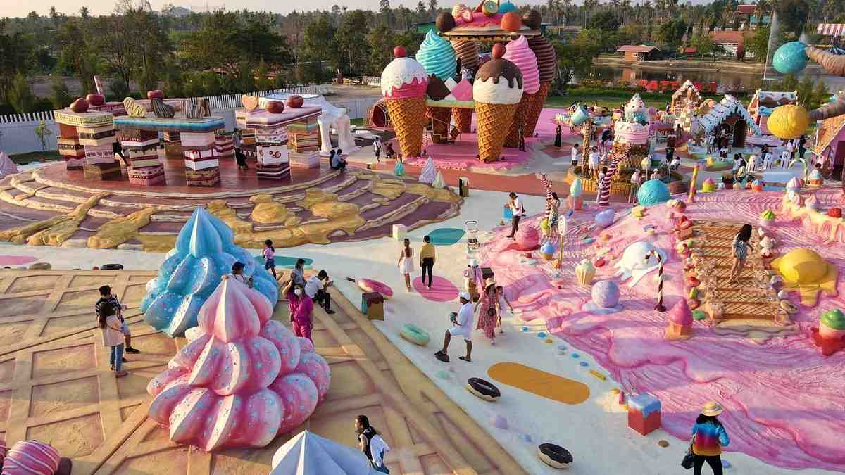 Taman wisata penuh warna Great & Grand Sweet Destination dengan bangunan berbentuk permen dan es krim raksasa, spot favorit untuk foto dalam paket open trip Bangkok.