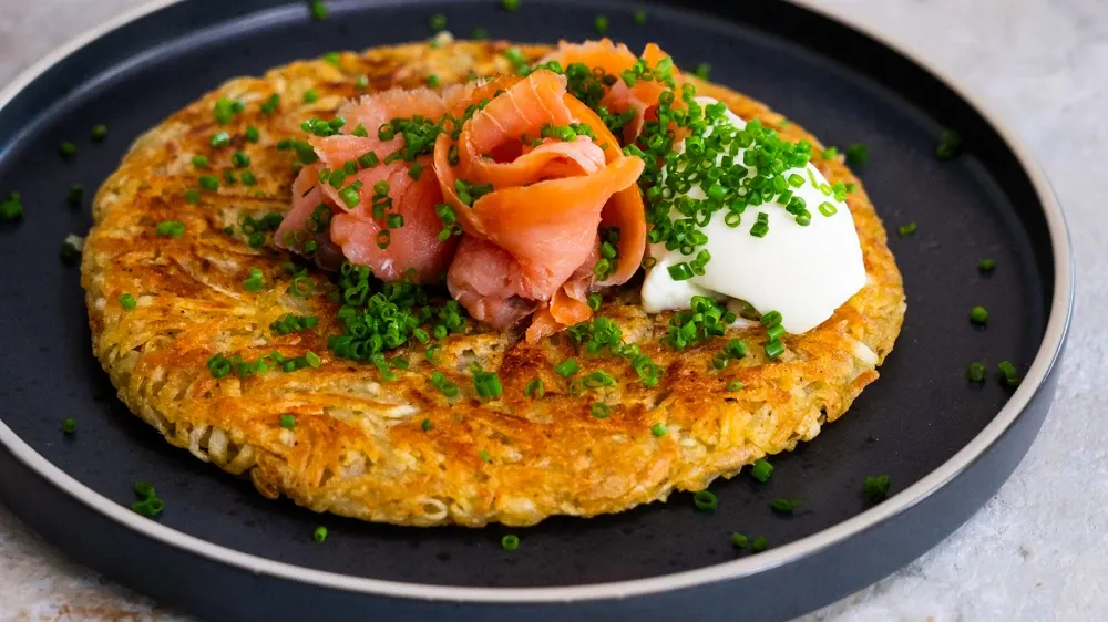 östi, makanan khas Swiss yang terbuat dari kentang parut digoreng renyah, disajikan hangat sebagai hidangan tradisional yang menggugah selera.